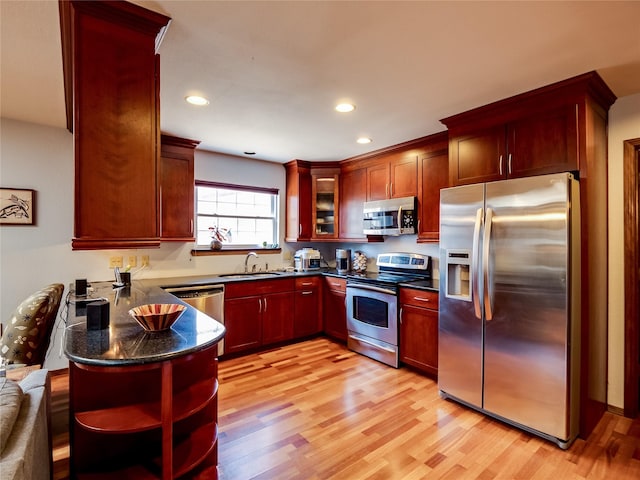 kitchen featuring open shelves, stainless steel appliances, light wood-style floors, dark brown cabinets, and a peninsula