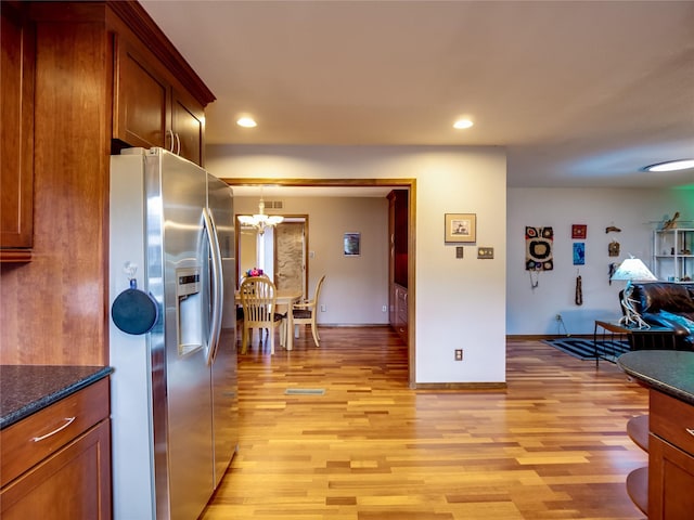 kitchen featuring light wood finished floors, an inviting chandelier, recessed lighting, and stainless steel fridge with ice dispenser