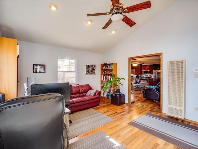 living room featuring light wood finished floors, ceiling fan, vaulted ceiling, and recessed lighting