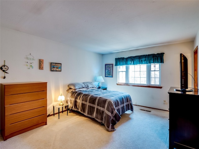 carpeted bedroom featuring visible vents