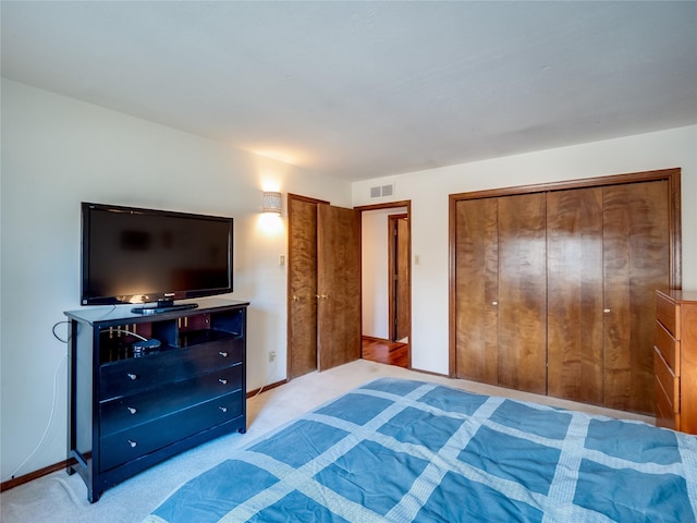 bedroom featuring light carpet, visible vents, and baseboards