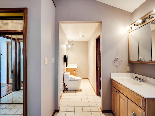 half bathroom featuring vanity, tile patterned flooring, toilet, and baseboards