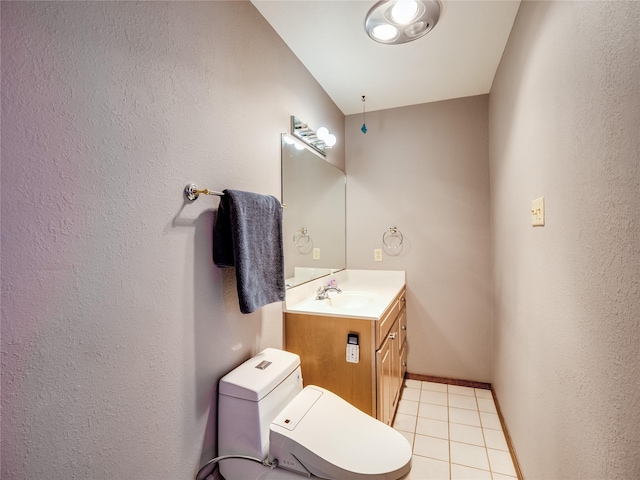 bathroom featuring toilet, tile patterned floors, baseboards, and vanity