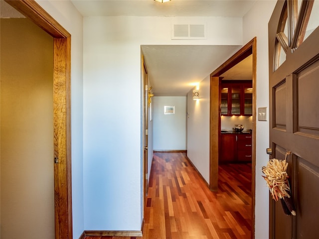 hallway with visible vents and wood finished floors