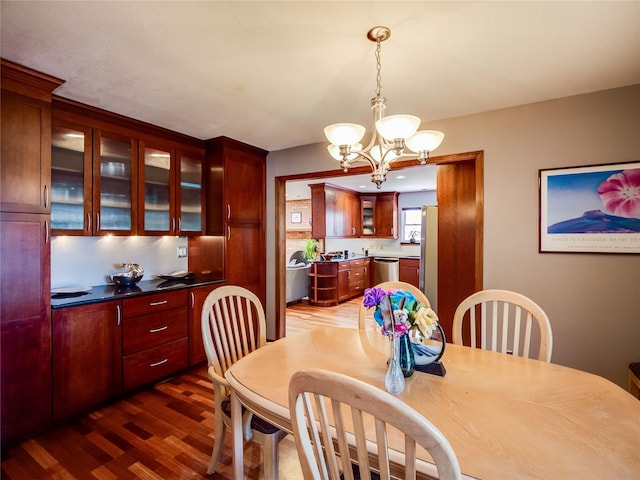 dining area featuring dark wood-type flooring and a notable chandelier