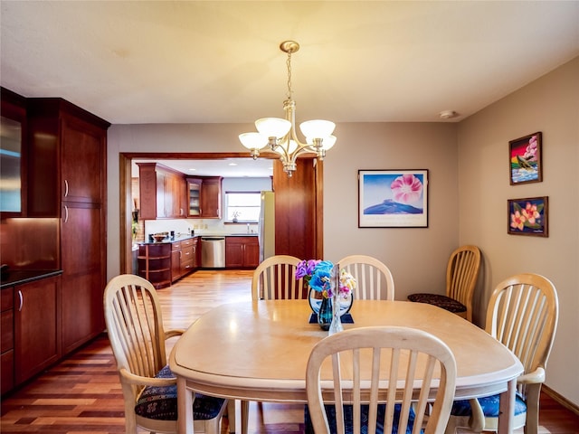 dining space featuring a notable chandelier and light wood-style floors