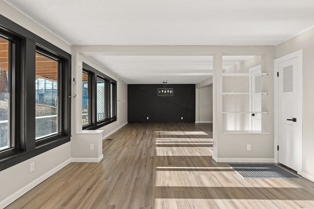 interior space with visible vents, baseboards, and wood finished floors