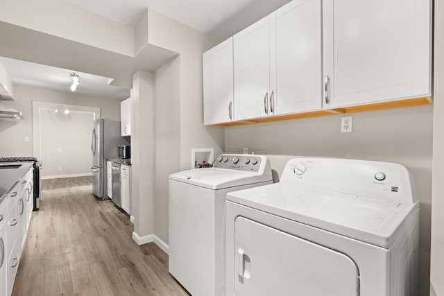 laundry room with laundry area, light wood-style flooring, baseboards, and washer and clothes dryer