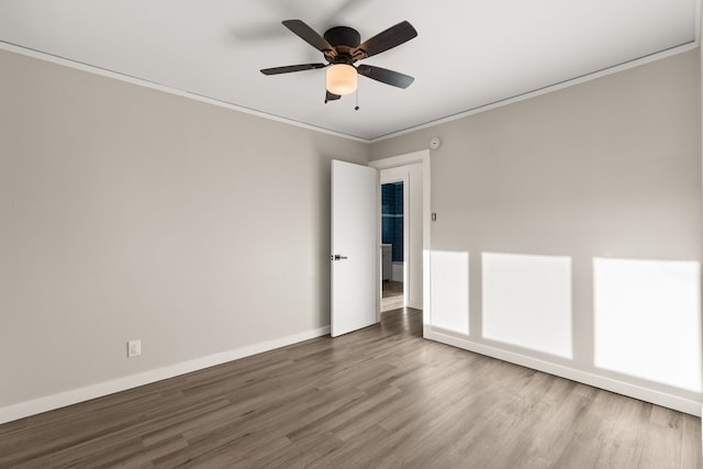 unfurnished room with ceiling fan, ornamental molding, wood finished floors, and baseboards