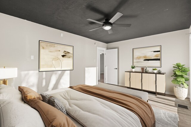 bedroom featuring light wood-type flooring, ceiling fan, and visible vents