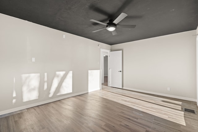 empty room with visible vents, baseboards, and wood finished floors