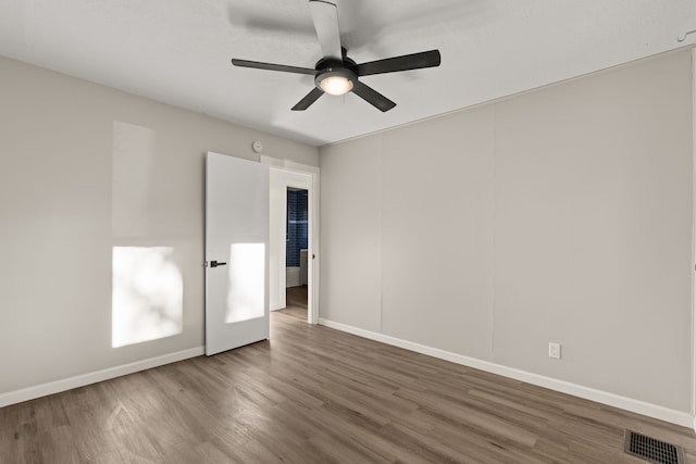 unfurnished room with a ceiling fan, baseboards, visible vents, and wood finished floors