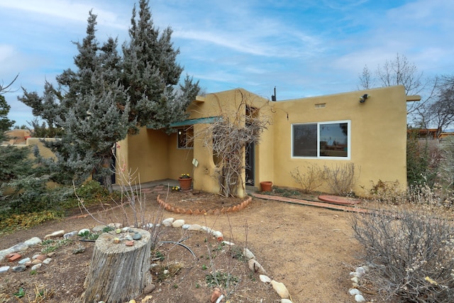 back of property featuring stucco siding