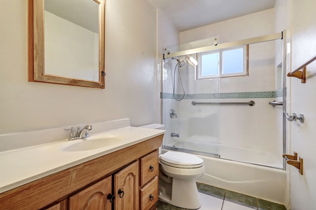 bathroom featuring combined bath / shower with glass door, vanity, toilet, and tile patterned floors