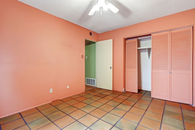 unfurnished bedroom with a textured ceiling, visible vents, a closet, and light tile patterned flooring