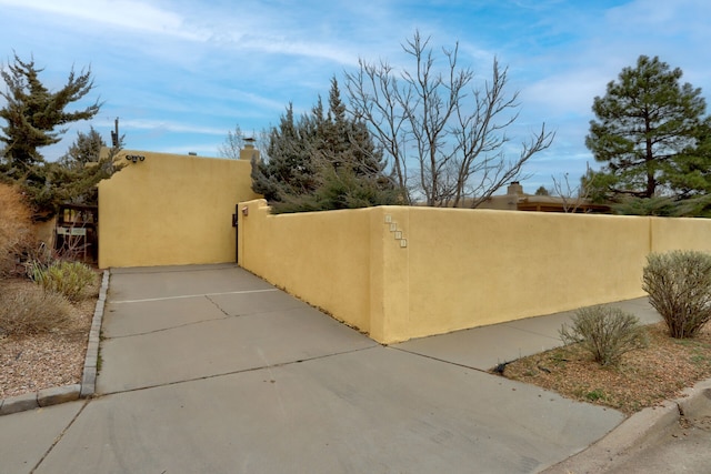 exterior space with a fenced front yard, a chimney, and stucco siding