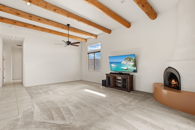 living area featuring light carpet, a warm lit fireplace, ceiling fan, and beam ceiling