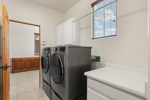 laundry area featuring cabinet space, light tile patterned floors, and separate washer and dryer