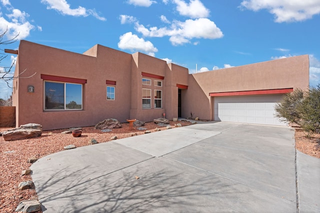 southwest-style home with driveway, a garage, and stucco siding