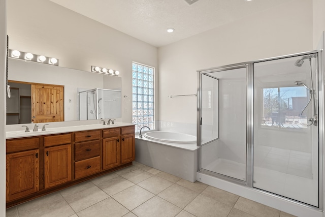 full bathroom with a sink, a shower stall, a bath, tile patterned floors, and double vanity