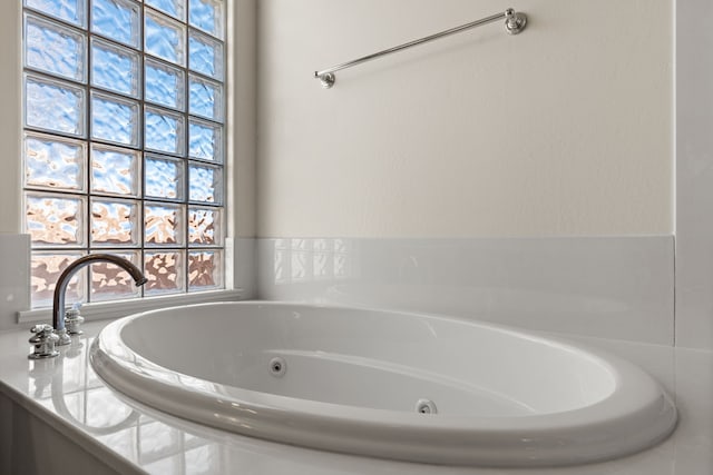 bathroom featuring a wealth of natural light and a whirlpool tub