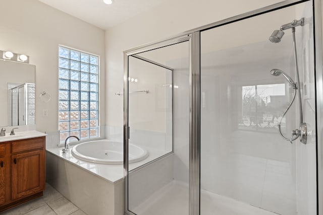 bathroom with a stall shower, a healthy amount of sunlight, a garden tub, and vanity