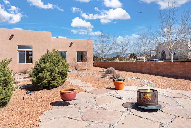 view of yard with a patio area, fence, and a fire pit