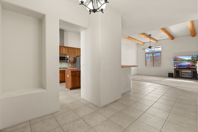 interior space with light tile patterned floors, a high ceiling, ceiling fan with notable chandelier, and beam ceiling