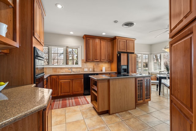 kitchen with open shelves, a sink, brown cabinets, black appliances, and tasteful backsplash