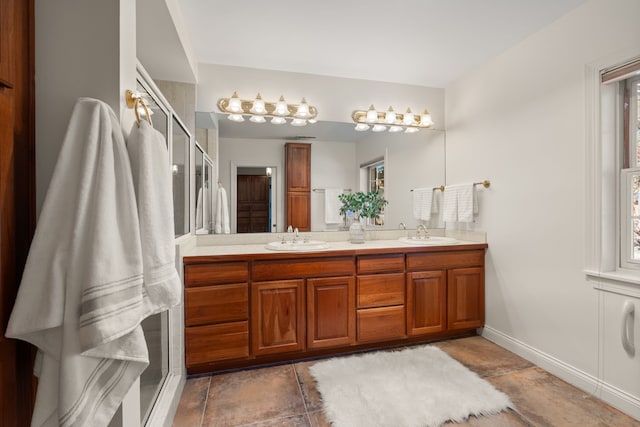 bathroom featuring a sink, a shower stall, baseboards, and double vanity