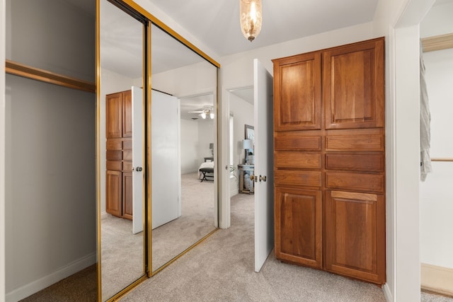 corridor featuring light carpet and baseboards