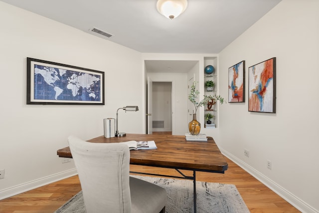 dining area with visible vents, light wood-style flooring, and baseboards