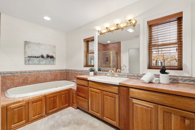 full bath with a stall shower, a garden tub, and vanity