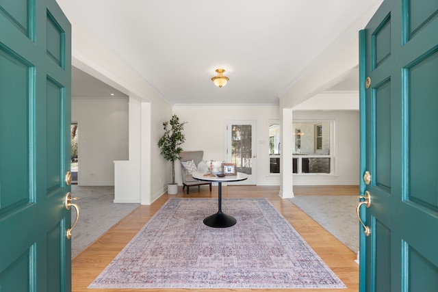 entryway featuring crown molding, light wood-style flooring, and baseboards