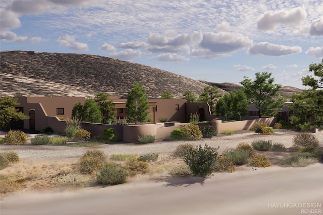 view of front facade featuring a fenced front yard, a mountain view, and stucco siding