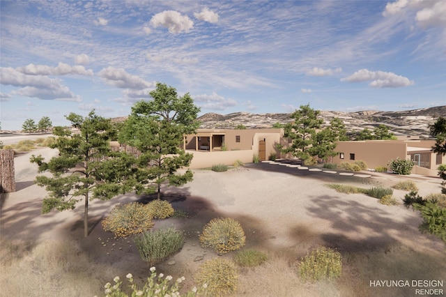 pueblo revival-style home featuring a mountain view and stucco siding