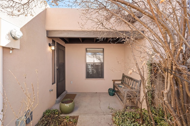 property entrance featuring a patio and stucco siding