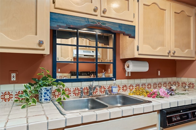 kitchen with a sink, tile countertops, and dishwashing machine