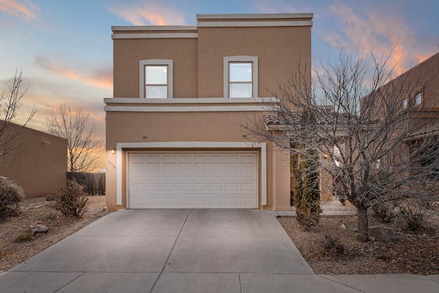 view of front of home featuring a garage, concrete driveway, and stucco siding