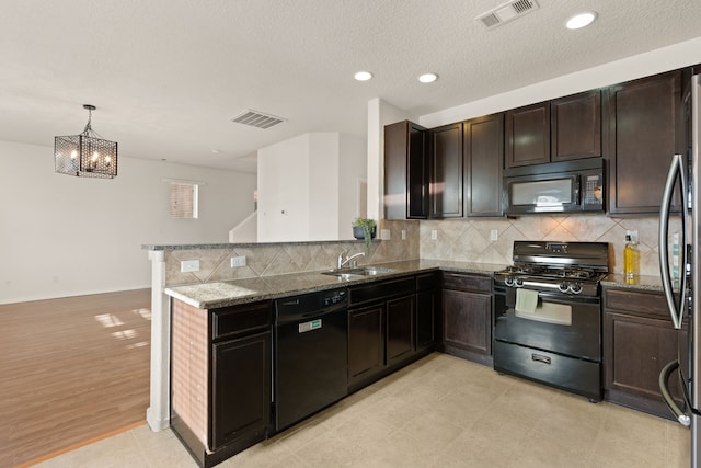 kitchen with dark stone counters, visible vents, a sink, and black appliances