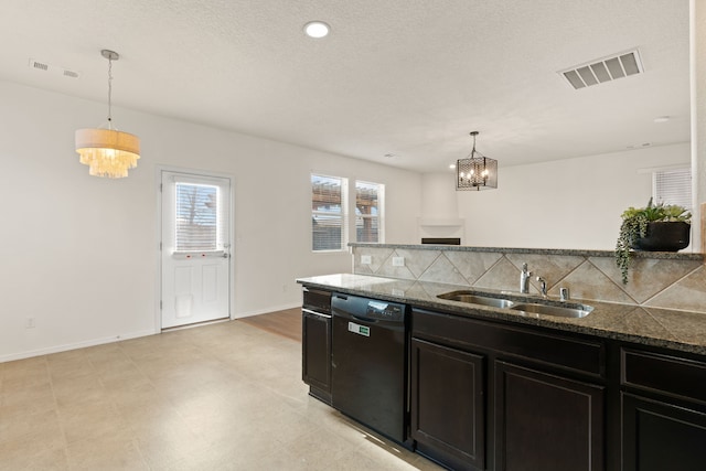 kitchen featuring dishwasher, dark stone countertops, a sink, and visible vents