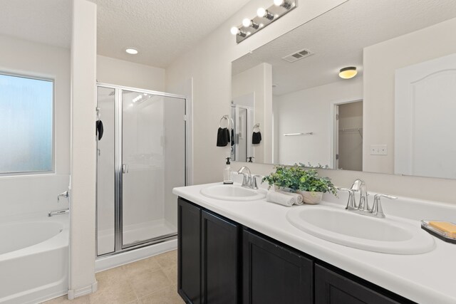 bathroom with a stall shower, visible vents, and a sink