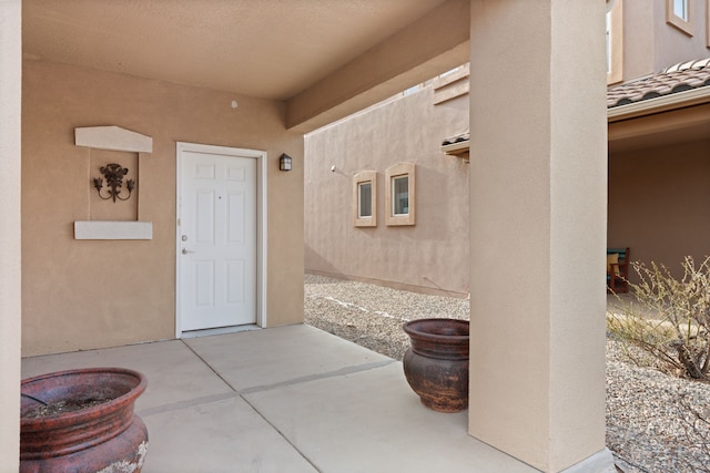 doorway to property featuring a patio area and stucco siding