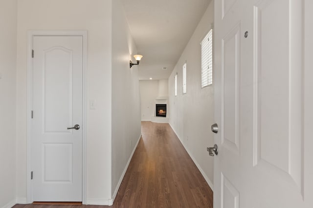 hallway featuring dark wood-style floors and baseboards