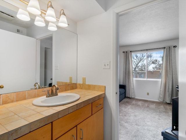 bathroom featuring vanity, baseboards, and visible vents