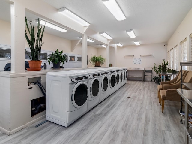 shared laundry area featuring light wood-type flooring and separate washer and dryer