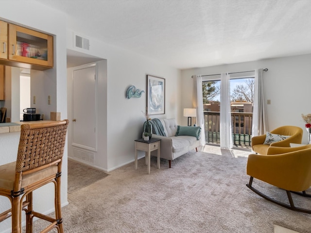 living area featuring visible vents, carpet floors, and baseboards