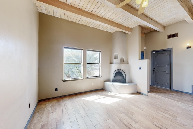 unfurnished living room featuring a ceiling fan, a large fireplace, visible vents, and light wood finished floors