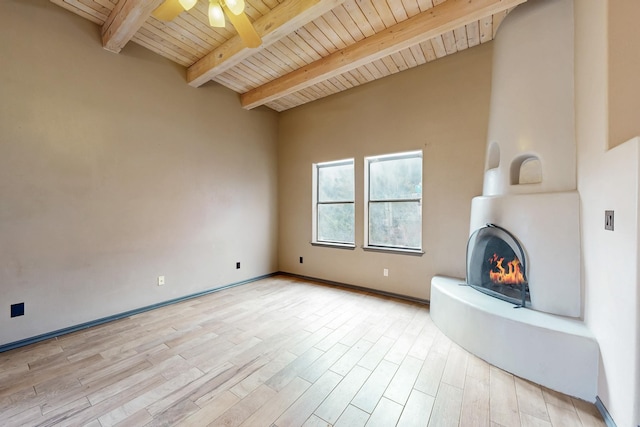 unfurnished living room featuring wooden ceiling, light wood-style flooring, ceiling fan, beamed ceiling, and a fireplace