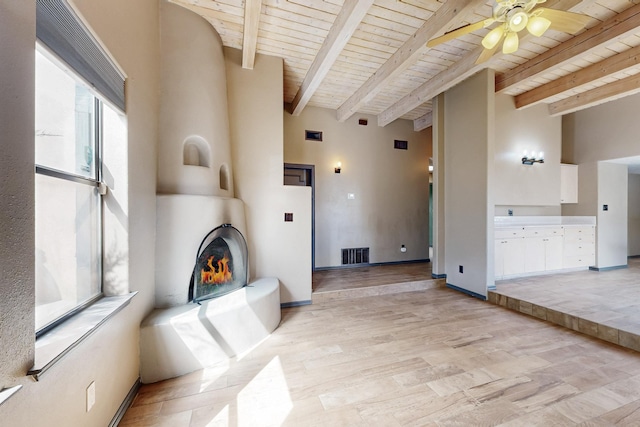 unfurnished living room featuring wooden ceiling, ceiling fan, a fireplace, and visible vents